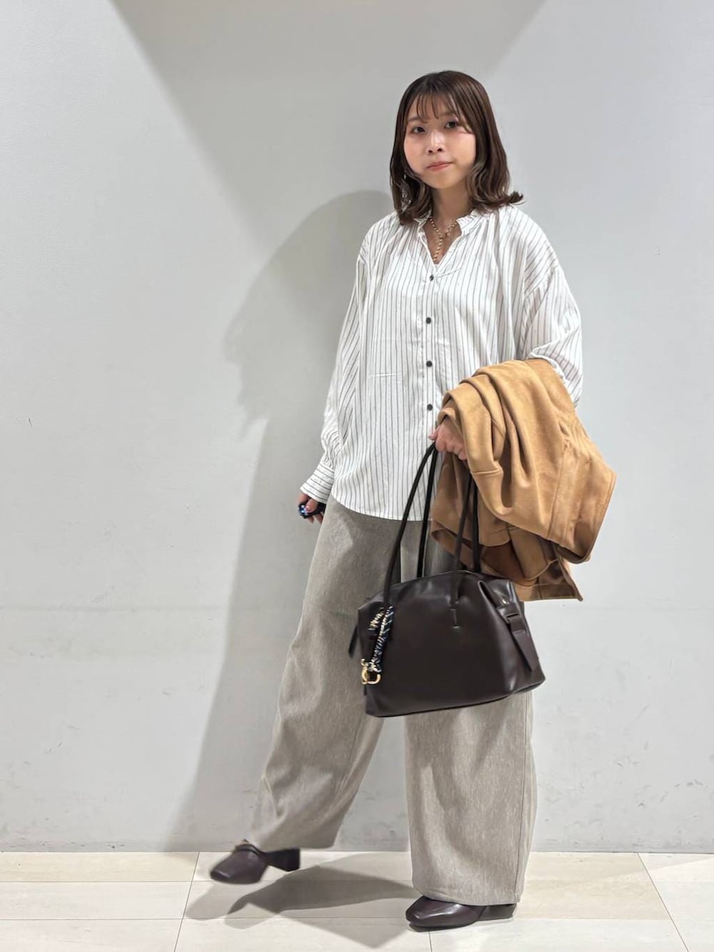 ブラウン系のローファー、ブラウン系のボストンバッグ、ブラウン系のテーラードジャケットを着用したレディースの春コーディネートの3枚目の写真