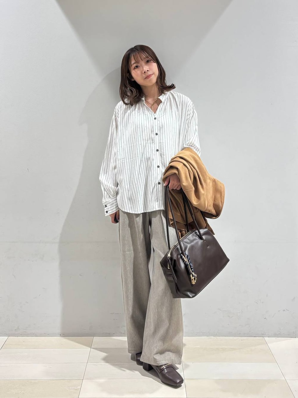 ブラウン系のローファー、ブラウン系のボストンバッグ、ブラウン系のテーラードジャケットを着用したレディースの春コーディネートの9枚目の写真
