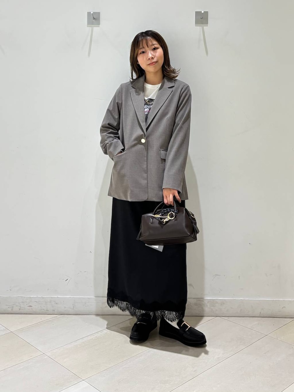 ブラック系のローファー、ブラウン系のテーラードジャケット、ブラウン系のボストンバッグを着用したレディースの春コーディネートの7枚目の写真