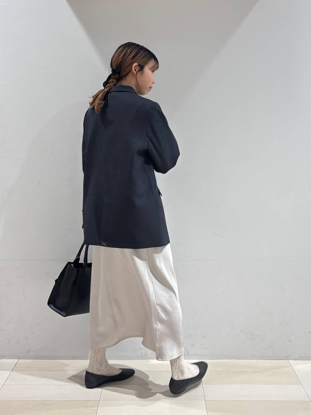 ブラック系のパンプス、ブラック系のシャツ/ブラウス、ブラック系のハンドバッグを着用したレディースの冬コーディネートの6枚目の写真