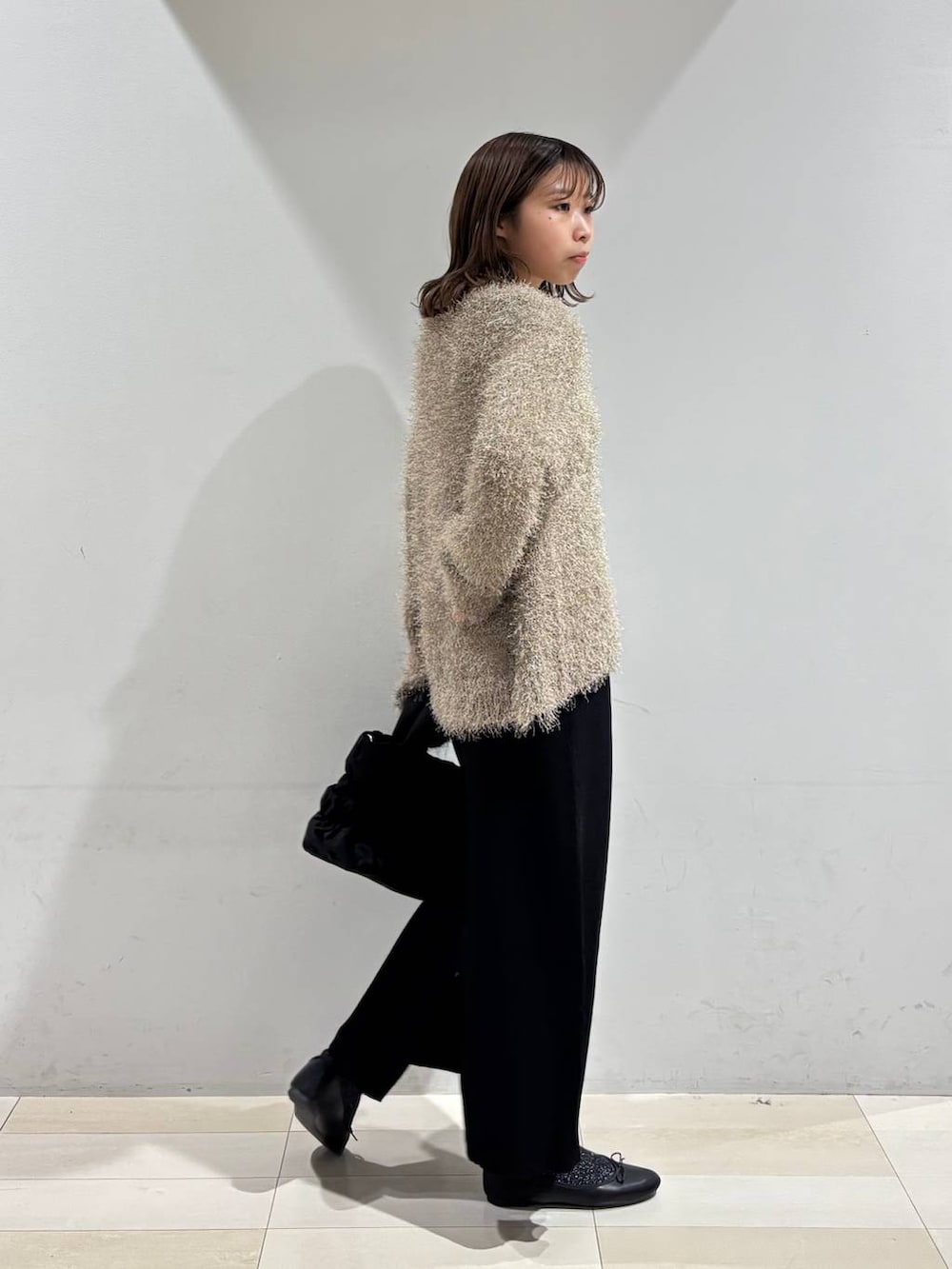 ブラック系のバレエシューズ、ブラック系のトートバッグ、ブラック系のスカートを着用したレディースの春コーディネートの6枚目の写真