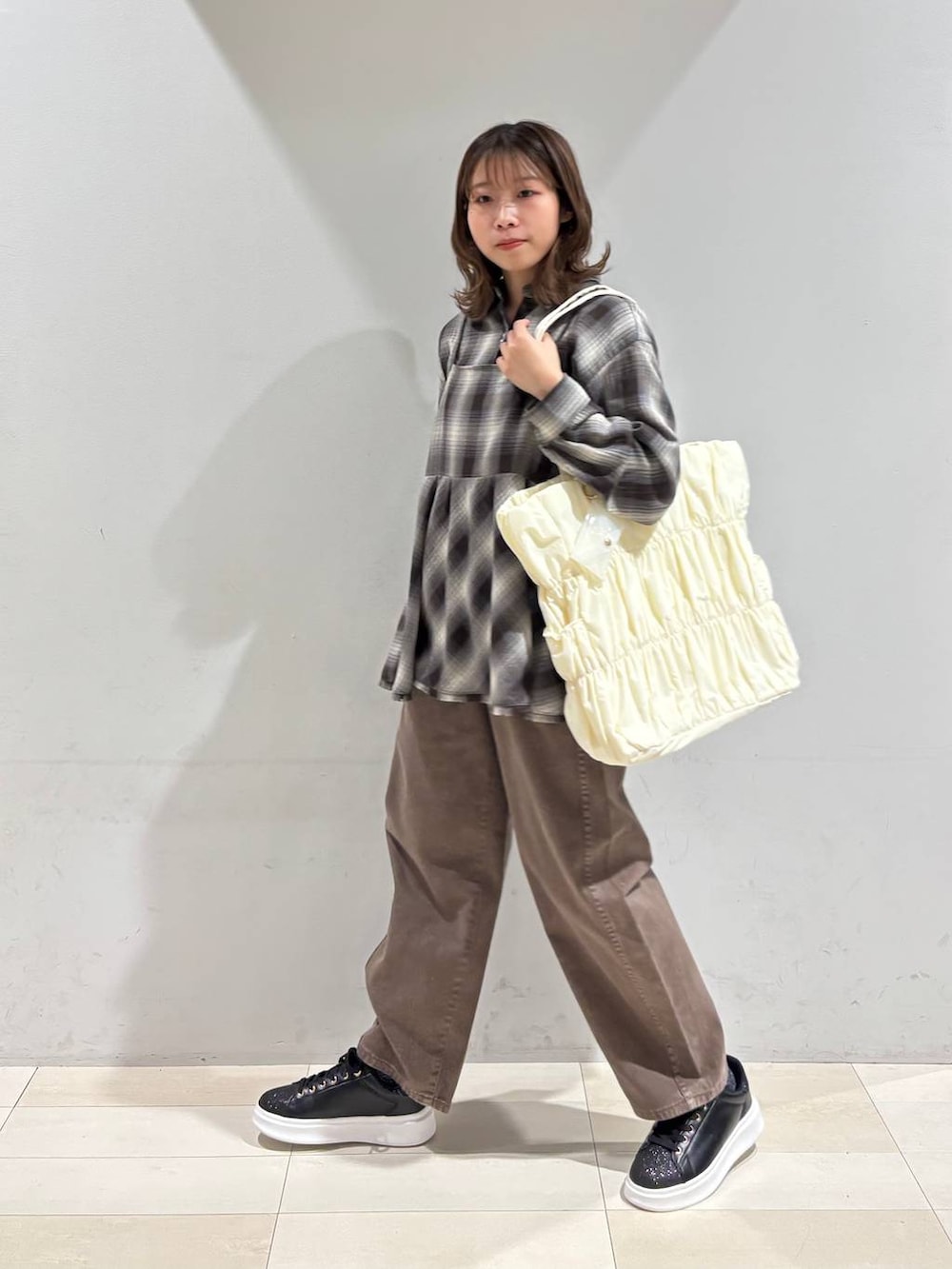 ベージュ系のトートバッグ、ブラウン系のデニムパンツ、ブラウン系のシャツ/ブラウスを着用したレディースの春コーディネートの4枚目の写真