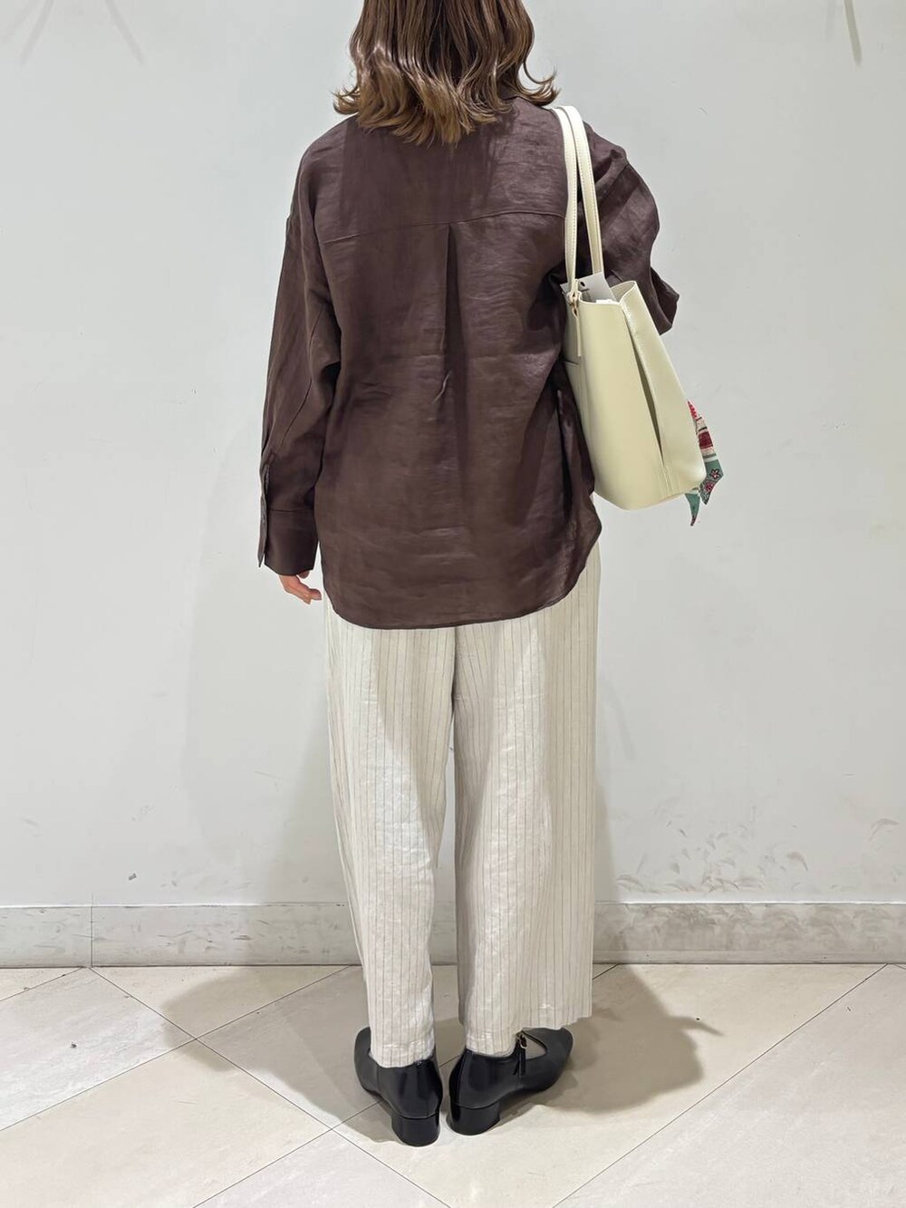 ブラック系のキャミソール、ブラウン系のシャツ/ブラウス、ベージュ系のその他パンツを着用したレディースの春コーディネートの5枚目の写真