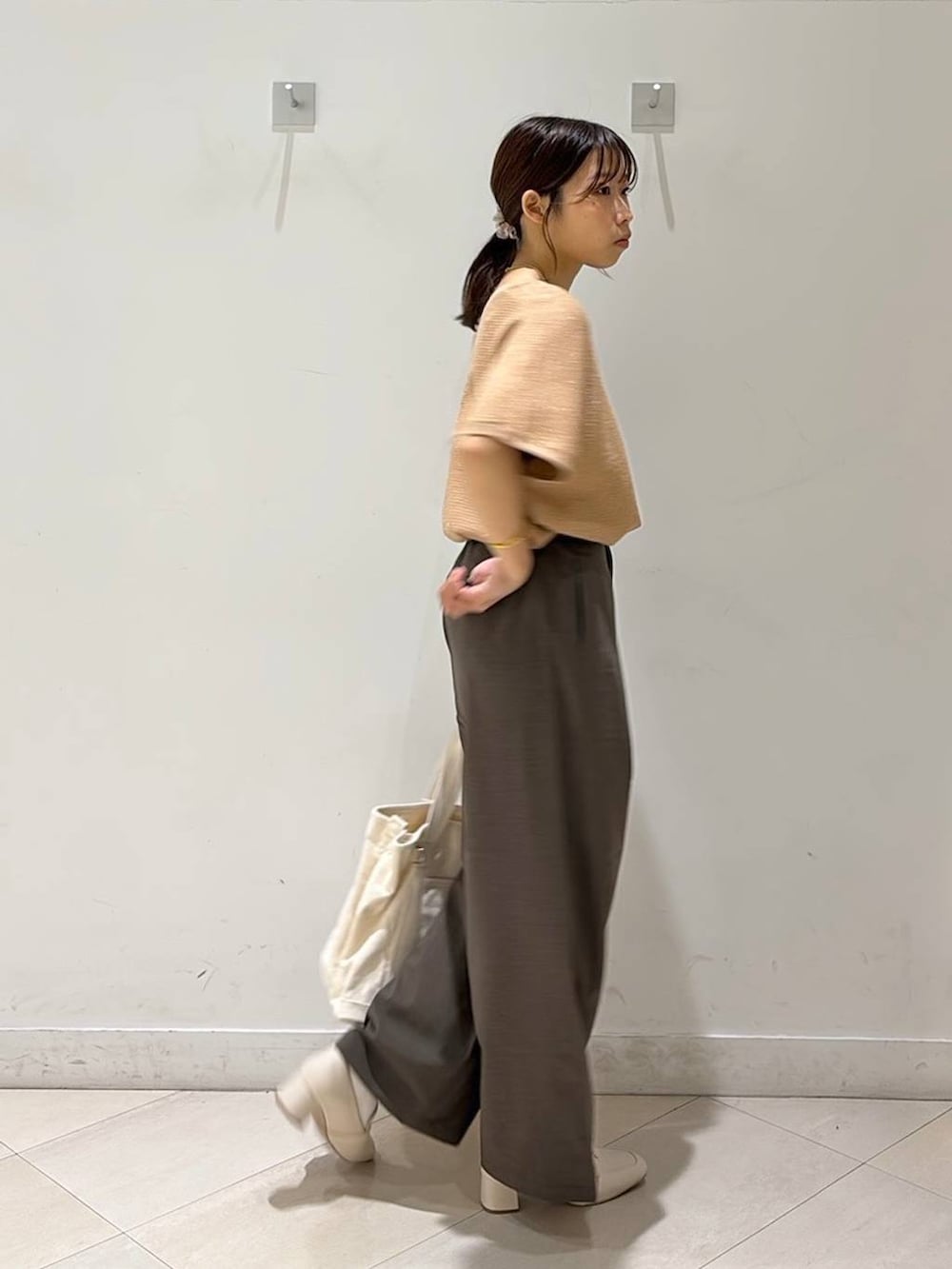ベージュ系のローファー、ホワイト系のトートバッグ、オレンジ系のニット/セーターを着用したレディースの春コーディネートの9枚目の写真