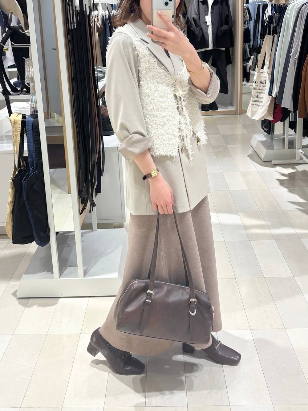 ブラウン系のローファー、ホワイト系のキャミソール、ベージュ系のテーラードジャケットを着用したレディースの春コーディネートの3枚目の写真