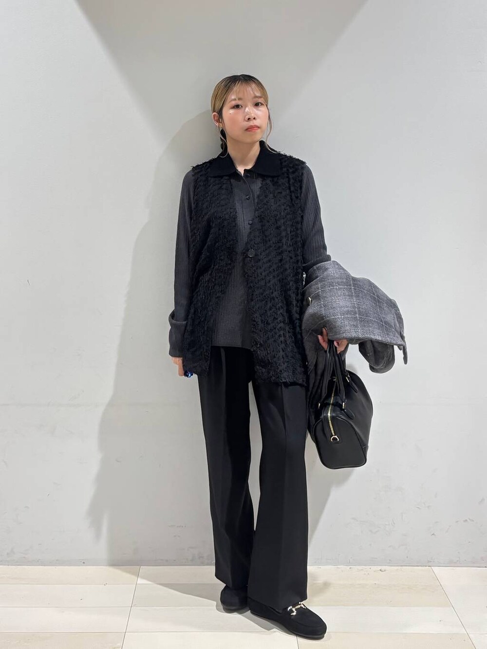 その他のチェスターコート、ブラック系のベスト、ブラック系のその他パンツを着用したレディースの秋コーディネートの2枚目の写真