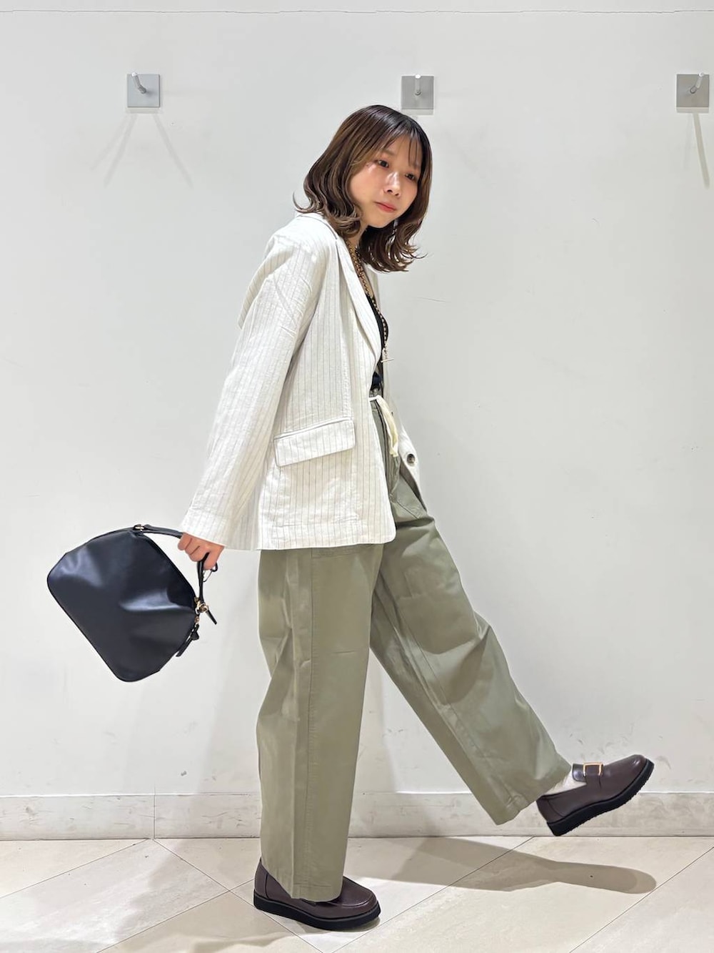 ブラック系のショルダーバッグ、ブラウン系のローファー、ブラック系のキャミソールを着用したレディースの春コーディネートの4枚目の写真