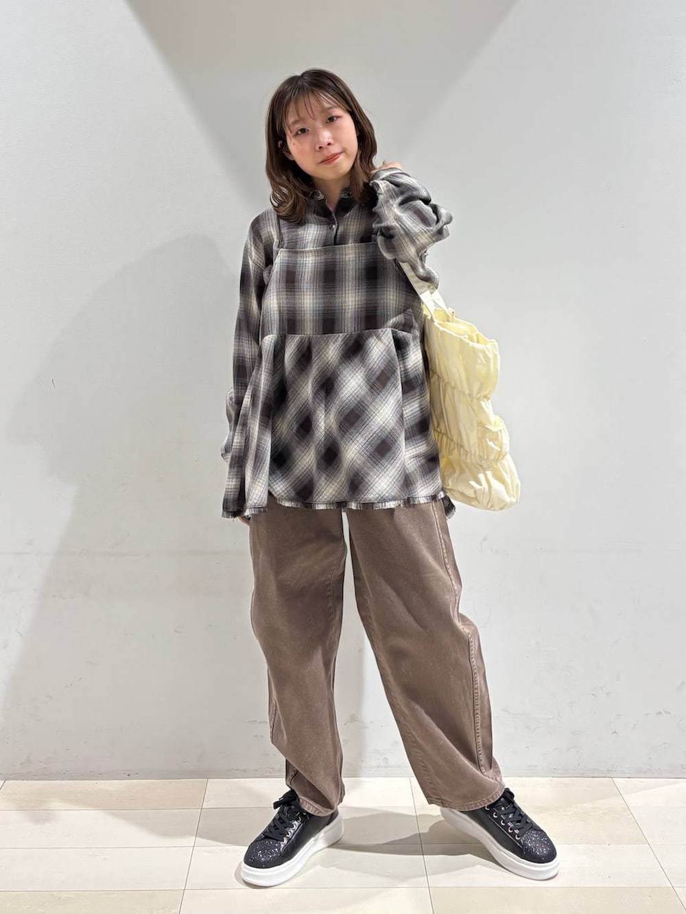 ベージュ系のトートバッグ、ブラウン系のデニムパンツ、ブラウン系のシャツ/ブラウスを着用したレディースの春コーディネートの2枚目の写真