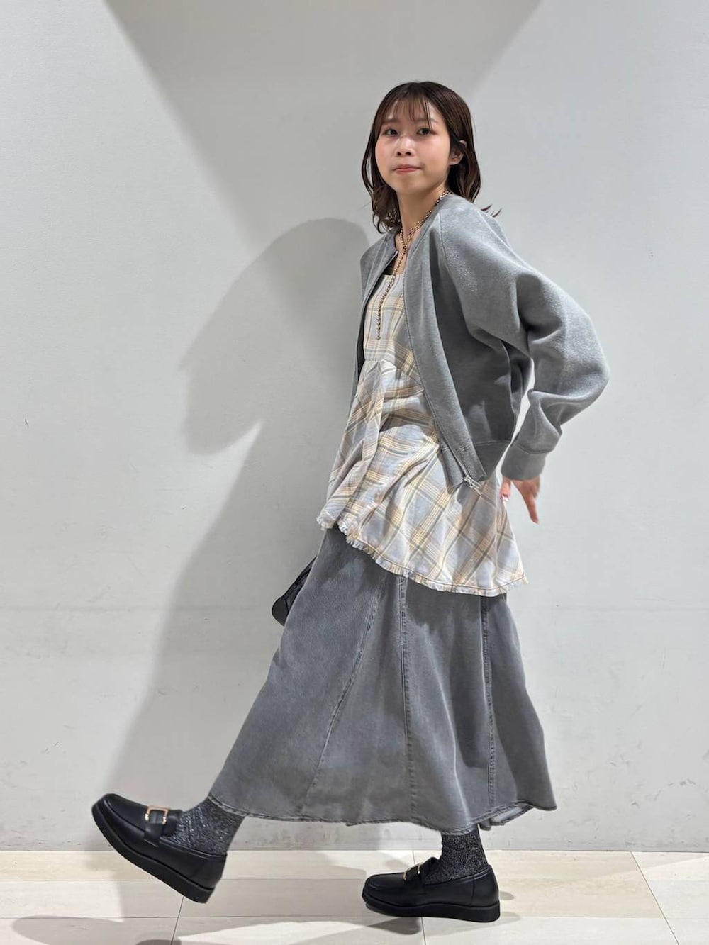 ブラック系のショルダーバッグ、ブラック系のローファー、ブルー系のその他トップスを着用したレディースの春コーディネートの5枚目の写真