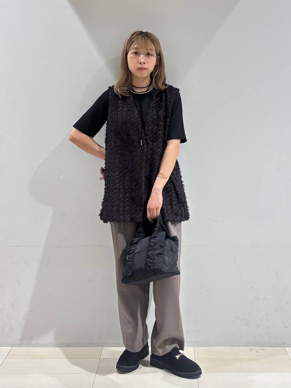 ブラック系のショルダーバッグ、ブラック系のTシャツ/カットソー、ブラック系のローファーを着用したレディースの秋コーディネートの7枚目の写真