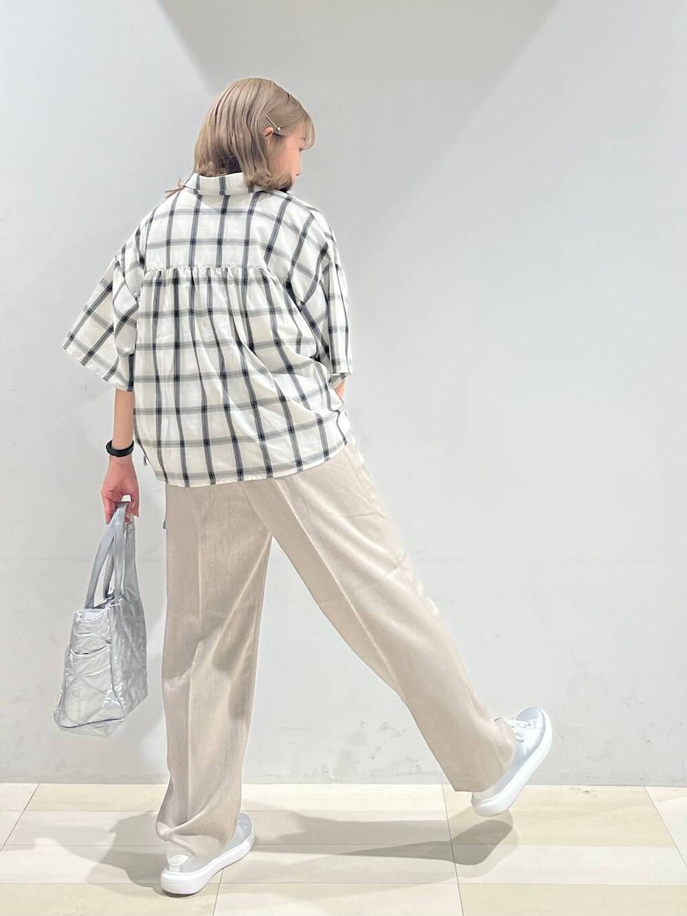 シルバー系のスニーカー、シルバー系のトートバッグ、ベージュ系のその他パンツを着用したレディースの夏コーディネートの4枚目の写真