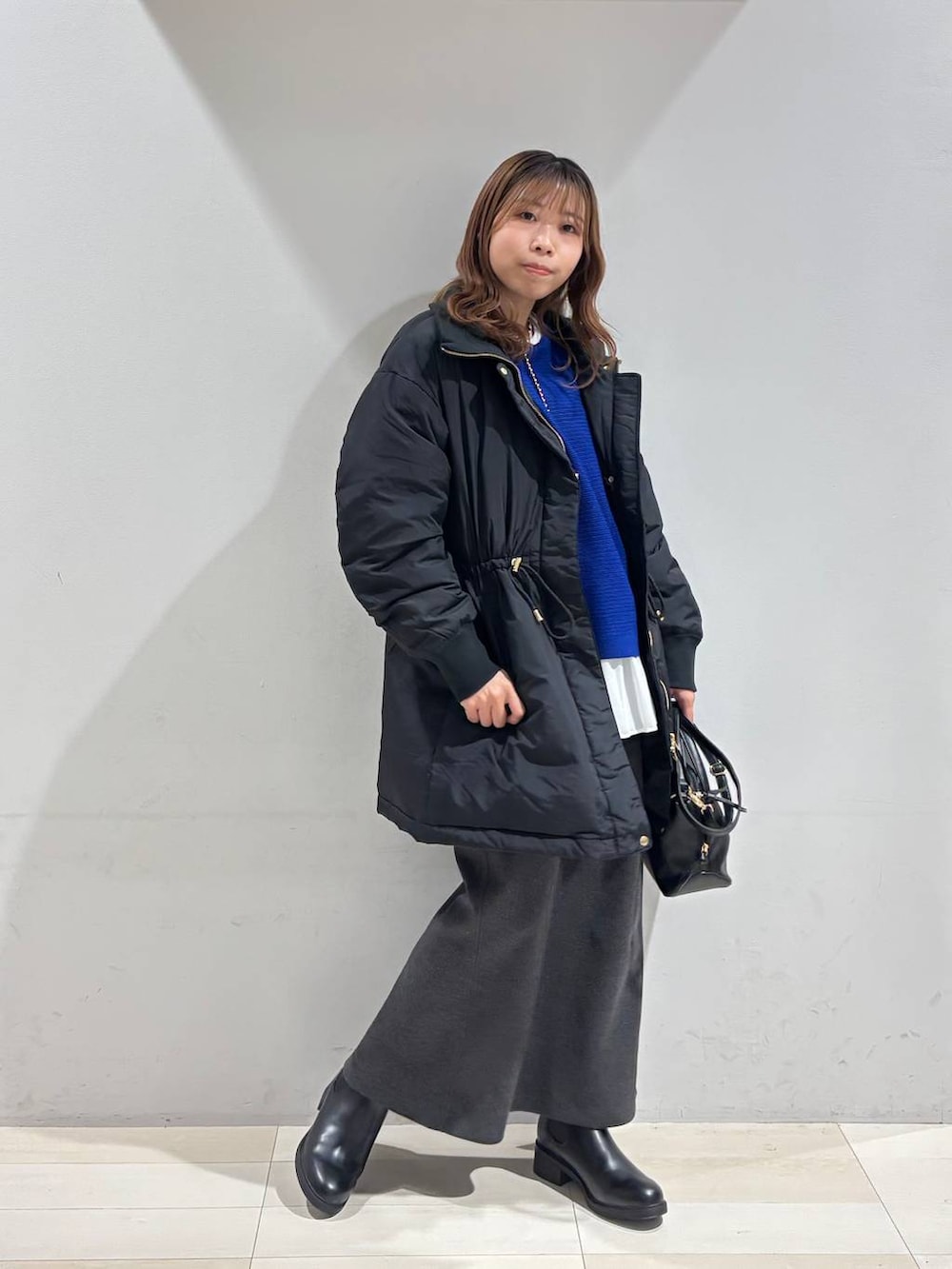 ブラック系のショルダーバッグ、ブラック系のダウンジャケット/コート、ホワイト系のTシャツ/カットソーを着用したレディースの冬コーディネートの7枚目の写真