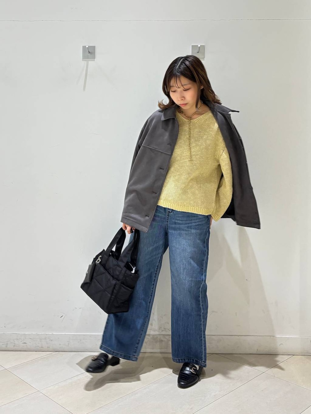 ブラック系のローファー、ブラック系のトートバッグ、ブルー系のデニムパンツを着用したレディースの春コーディネートの8枚目の写真