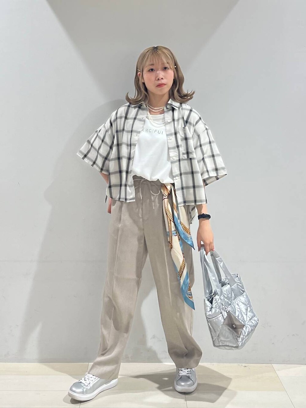 シルバー系のスニーカー、シルバー系のトートバッグ、ベージュ系のその他パンツを着用したレディースの夏コーディネートの2枚目の写真