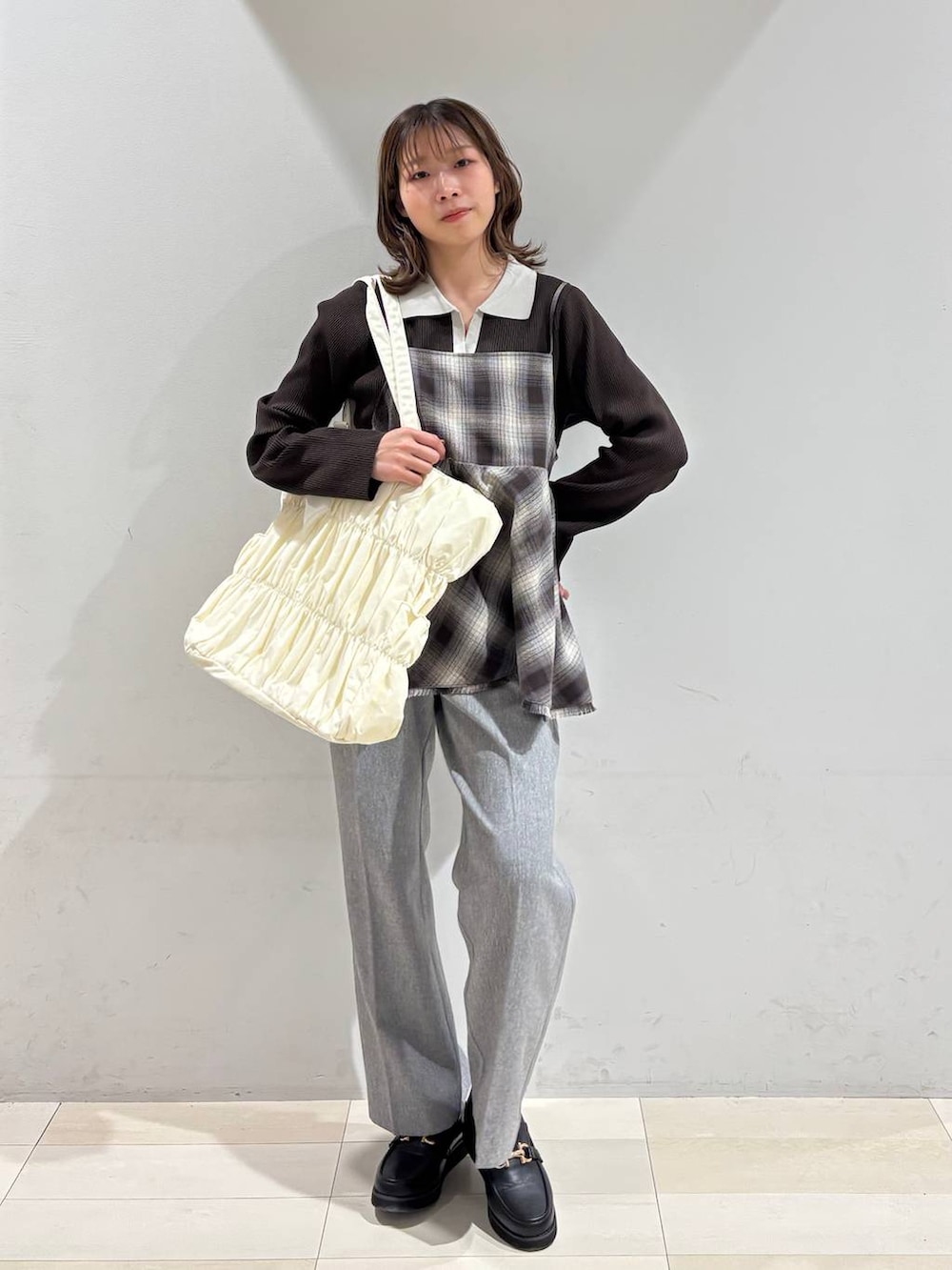 ブラック系のローファー、ベージュ系のトートバッグ、グレー系のその他パンツを着用したレディースの春コーディネートの9枚目の写真