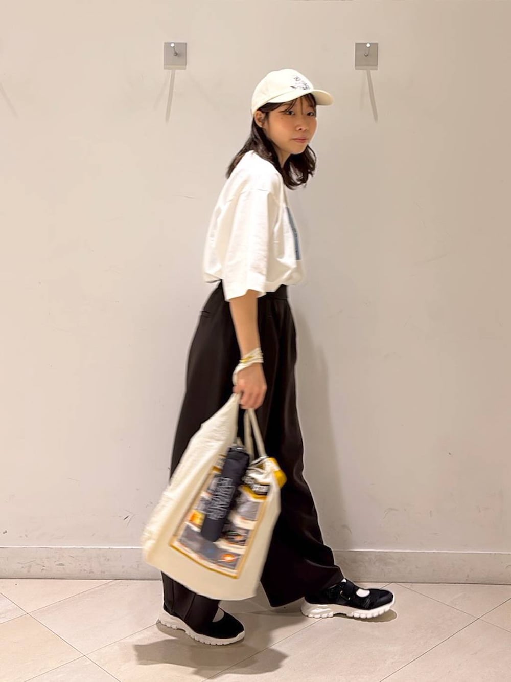 ブラック系のスニーカー、ブラウン系のその他パンツ、ホワイト系のエコバッグ/サブバッグを着用したレディースの春コーディネートの7枚目の写真
