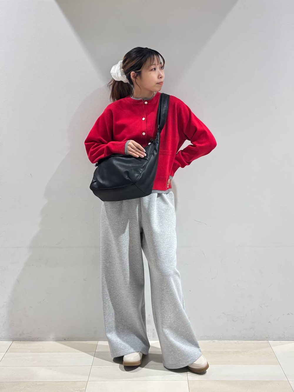 ホワイト系のローファー、ブラック系のショルダーバッグ、グレー系のスウェットパンツを着用したレディースの冬コーディネートの2枚目の写真