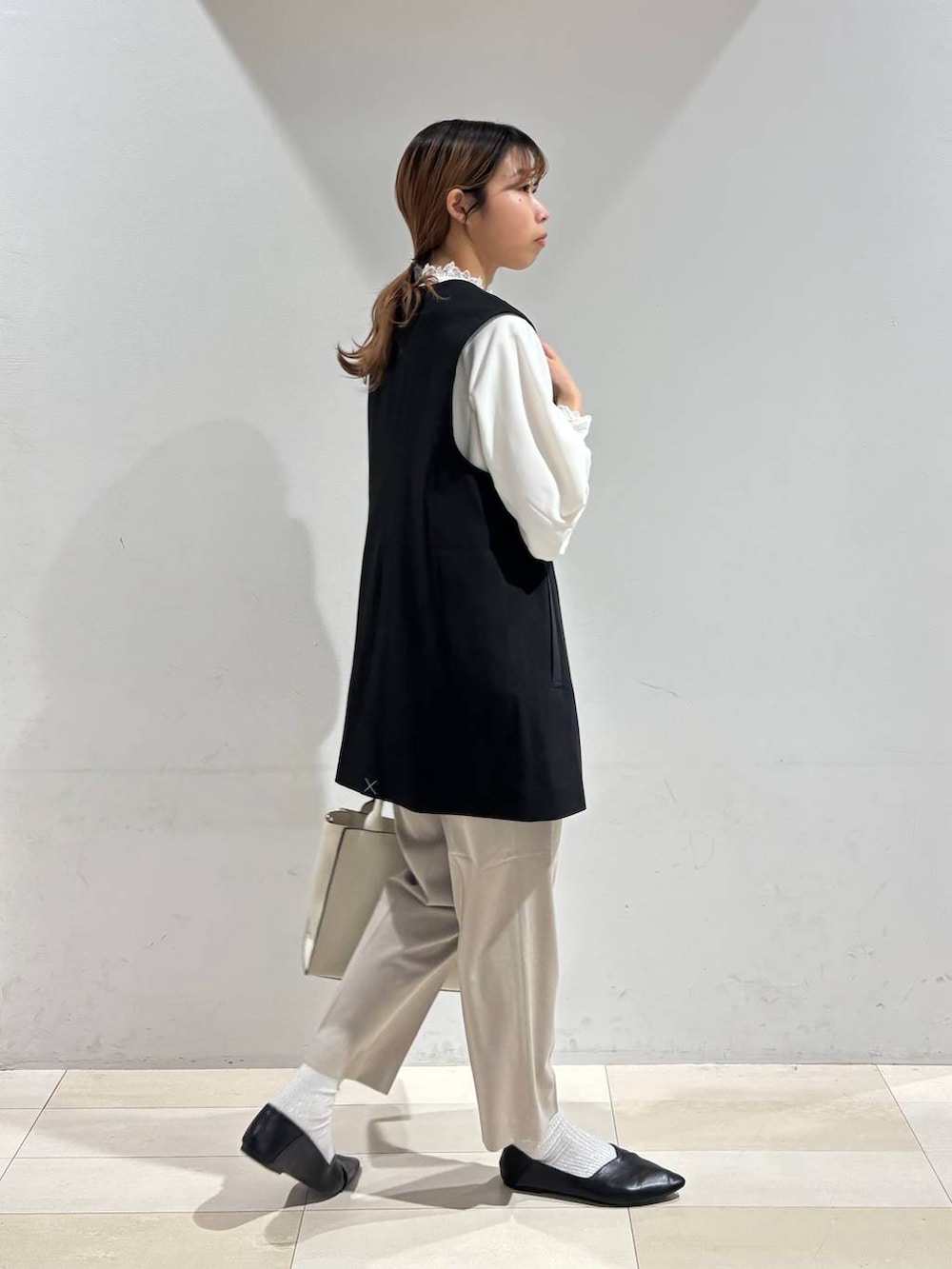 ブラック系のパンプス、ベージュ系のスラックス、ホワイト系のシャツ/ブラウスを着用したレディースの冬コーディネートの5枚目の写真