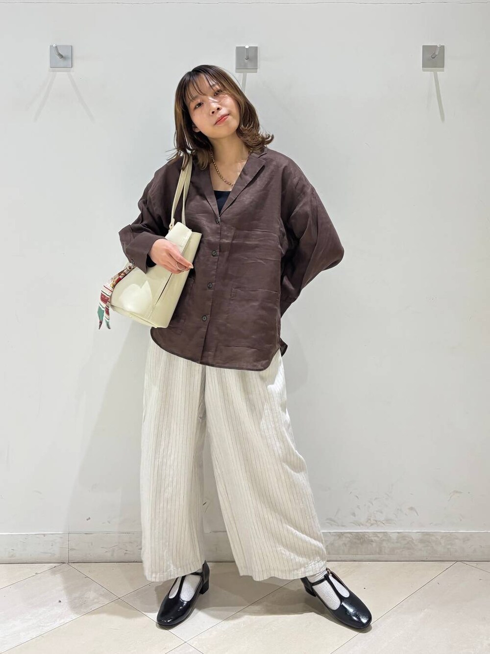 ブラック系のキャミソール、ブラウン系のシャツ/ブラウス、ベージュ系のその他パンツを着用したレディースの春コーディネートの4枚目の写真