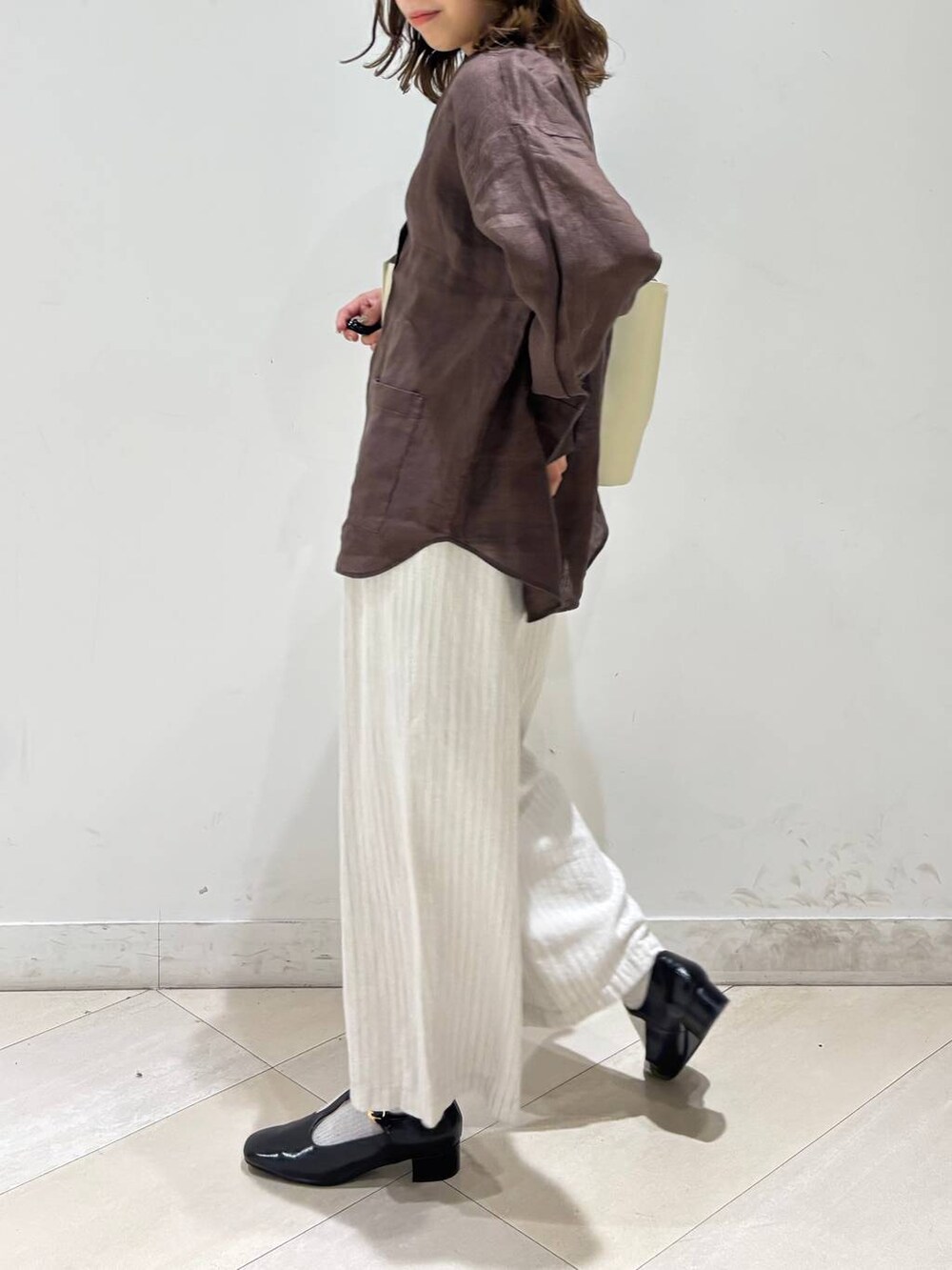 ブラック系のキャミソール、ブラウン系のシャツ/ブラウス、ベージュ系のその他パンツを着用したレディースの春コーディネートの7枚目の写真