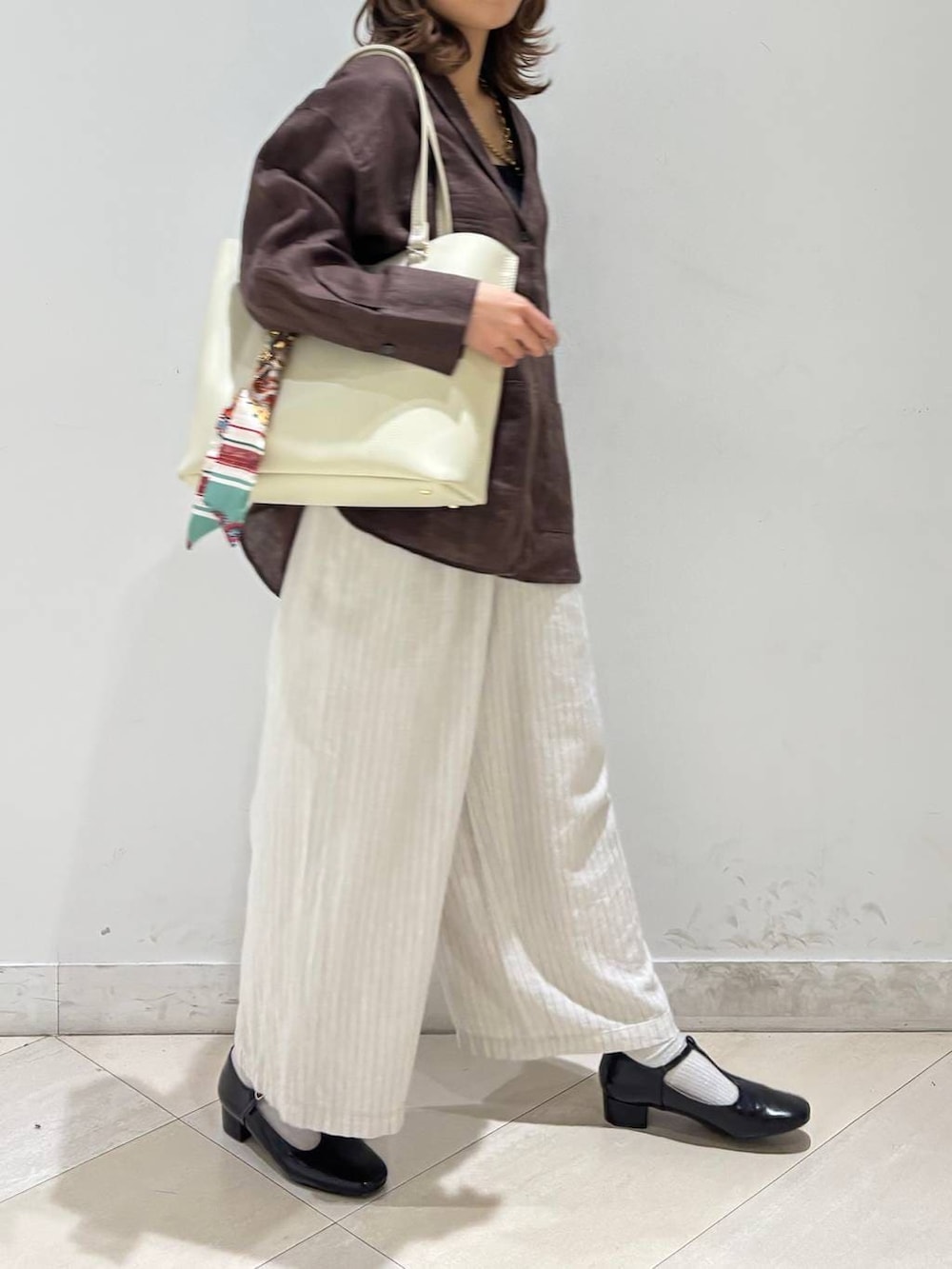 ブラック系のキャミソール、ブラウン系のシャツ/ブラウス、ベージュ系のその他パンツを着用したレディースの春コーディネートの3枚目の写真