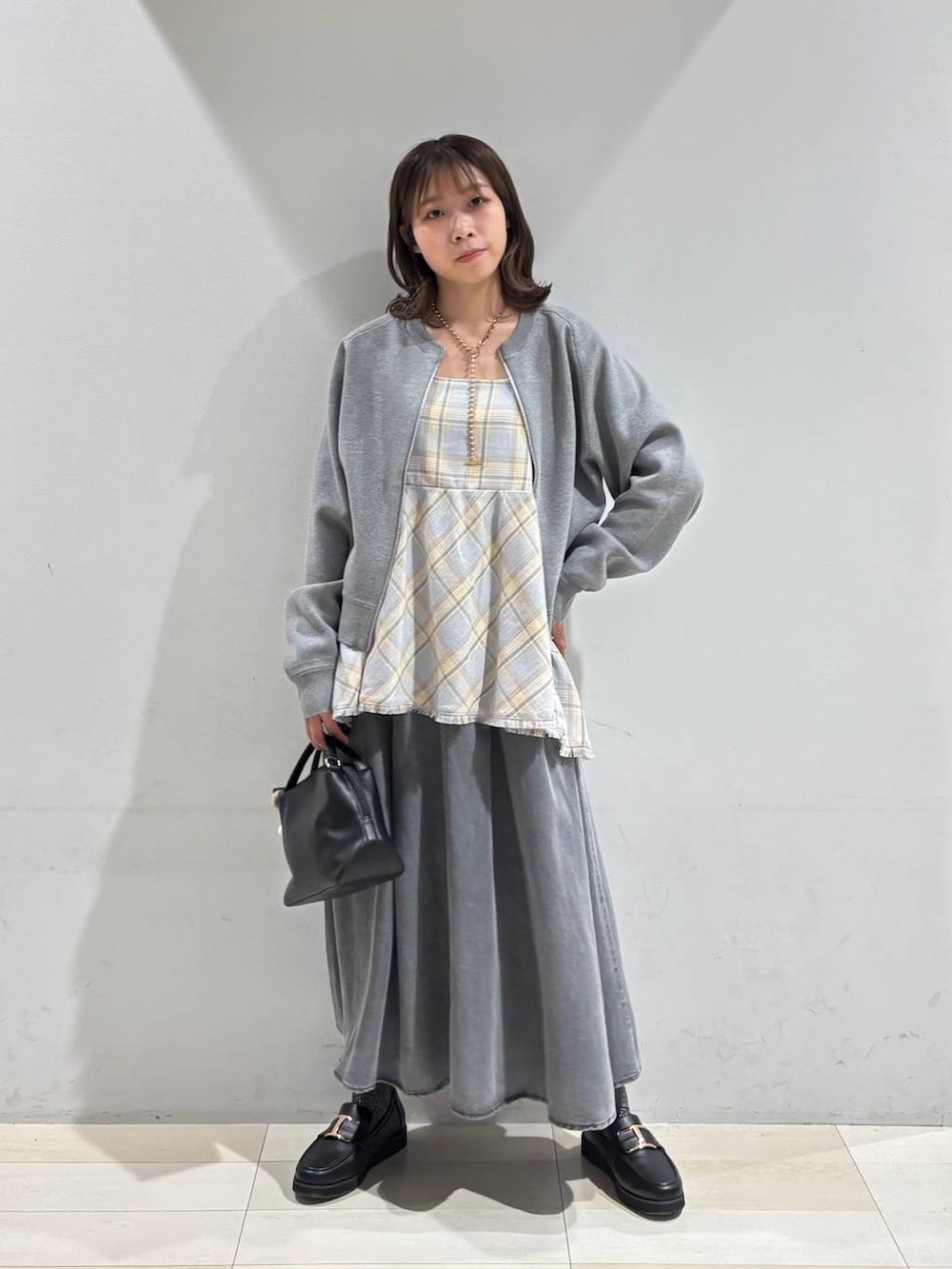 ブラック系のショルダーバッグ、ブラック系のローファー、ブルー系のその他トップスを着用したレディースの春コーディネートの7枚目の写真