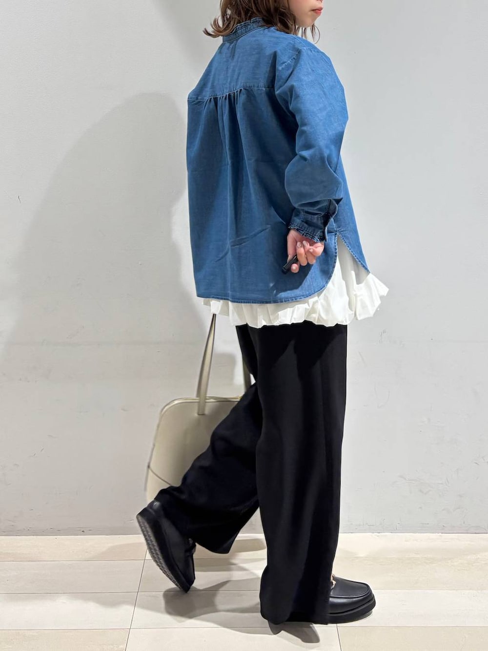 ブラック系のローファー、ベージュ系のボストンバッグ、ブルー系のシャツ/ブラウスを着用したレディースの春コーディネートの7枚目の写真