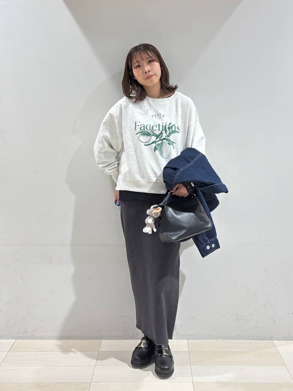 ブラック系のショルダーバッグ、ブラック系のローファー、ブラック系のTシャツ/カットソーを着用したレディースの冬コーディネートの7枚目の写真