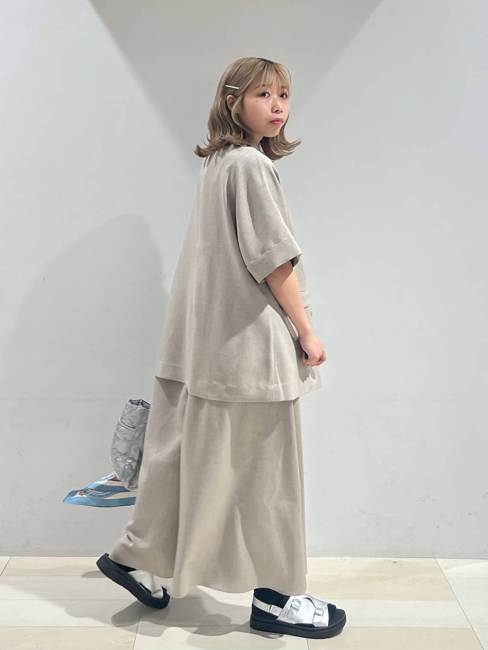 シルバー系のトートバッグ、ホワイト系のキャミソール、シルバー系のサンダルを着用したレディースの夏コーディネートの7枚目の写真