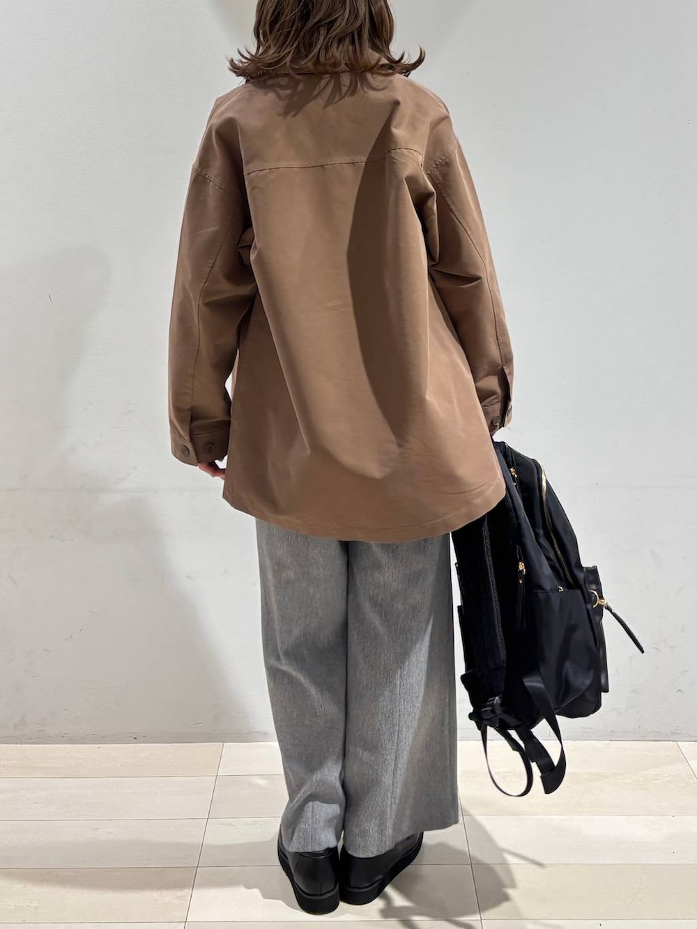 ブラック系のローファー、ブラック系のバックパック/リュック、グレー系のその他パンツを着用したレディースの春コーディネートの5枚目の写真