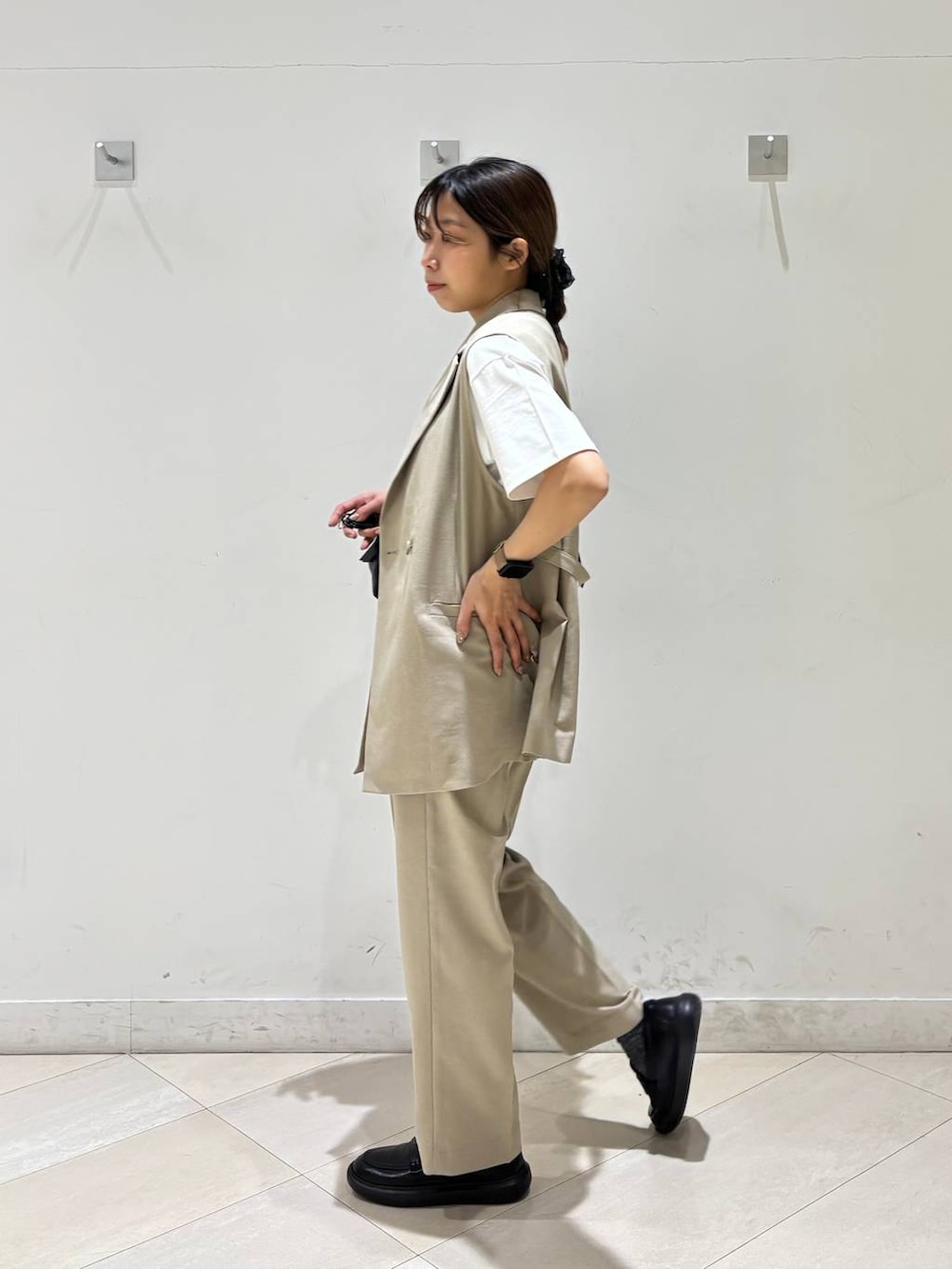 ブラック系のボストンバッグ、ベージュ系のその他パンツ、ベージュ系のベストを着用したレディースの春コーディネートの6枚目の写真