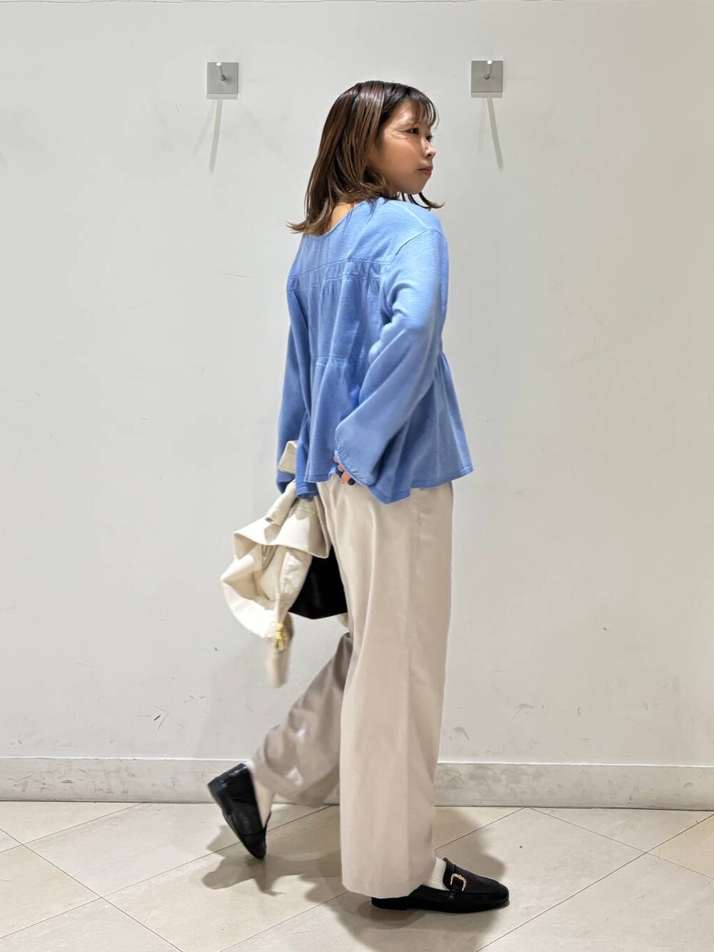 ブラック系のローファー、ホワイト系のその他パンツ、ブラウン系のボストンバッグを着用したレディースの春コーディネートの7枚目の写真