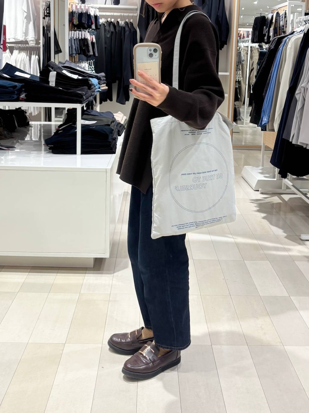 ブラウン系のローファー、ブルー系のデニムパンツ、ブラウン系のカーディガン/ボレロを着用したレディースの秋コーディネートの2枚目の写真