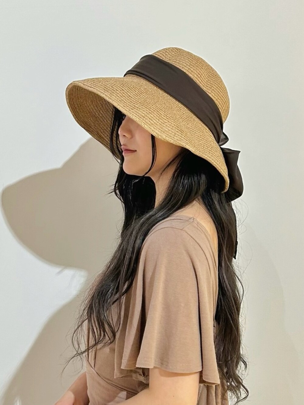 ベージュ系のハットを着用したレディースの夏コーディネートの2枚目の写真
