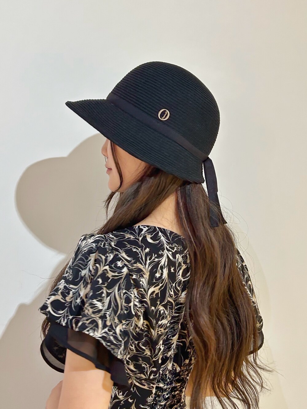 ブラック系のハットを着用したレディースの夏コーディネートの2枚目の写真