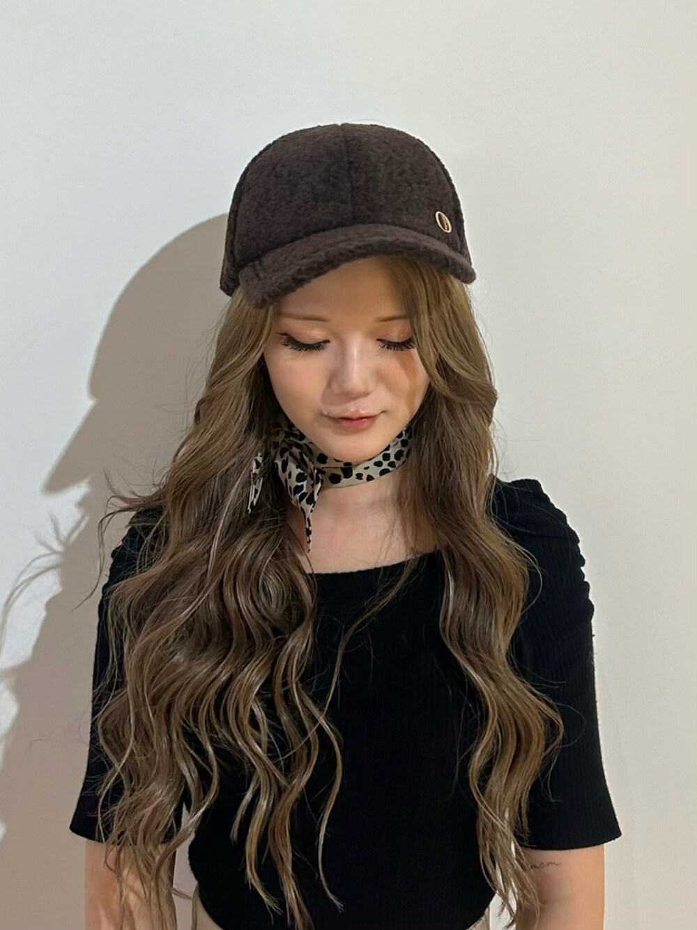 ブラウン系のキャップを着用したレディースの秋コーディネートの2枚目の写真