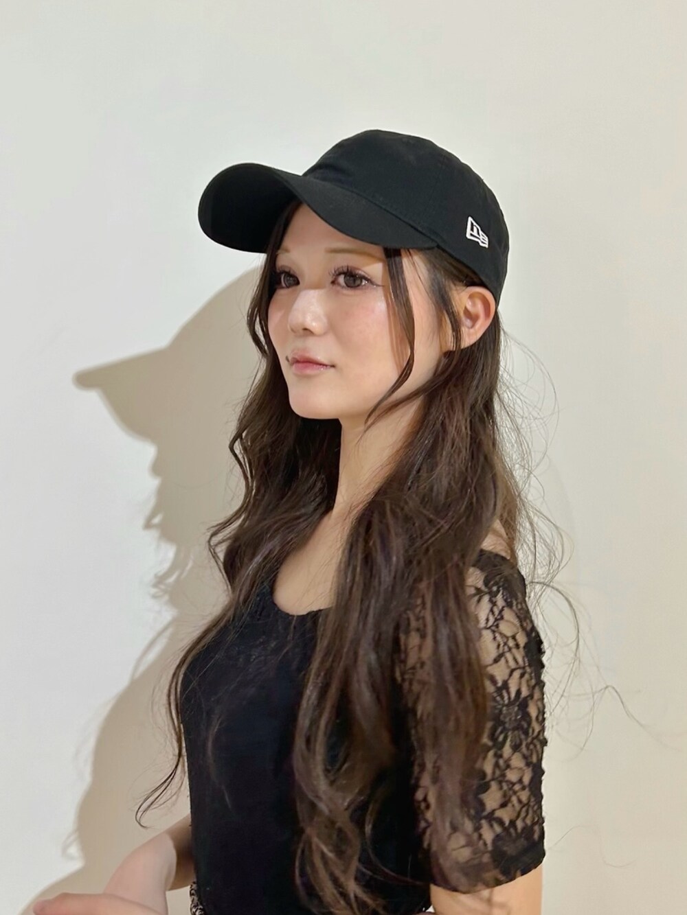 ブラック系のキャップを着用したレディースの春コーディネートの2枚目の写真