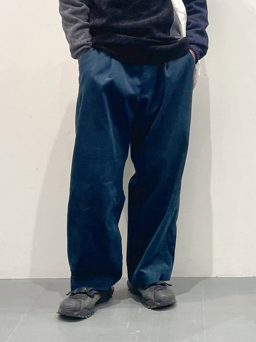 グレー系のニット/セーター、ホワイト系のショルダーバッグ、ブルー系のその他パンツを着用したメンズの秋コーディネートの2枚目の写真