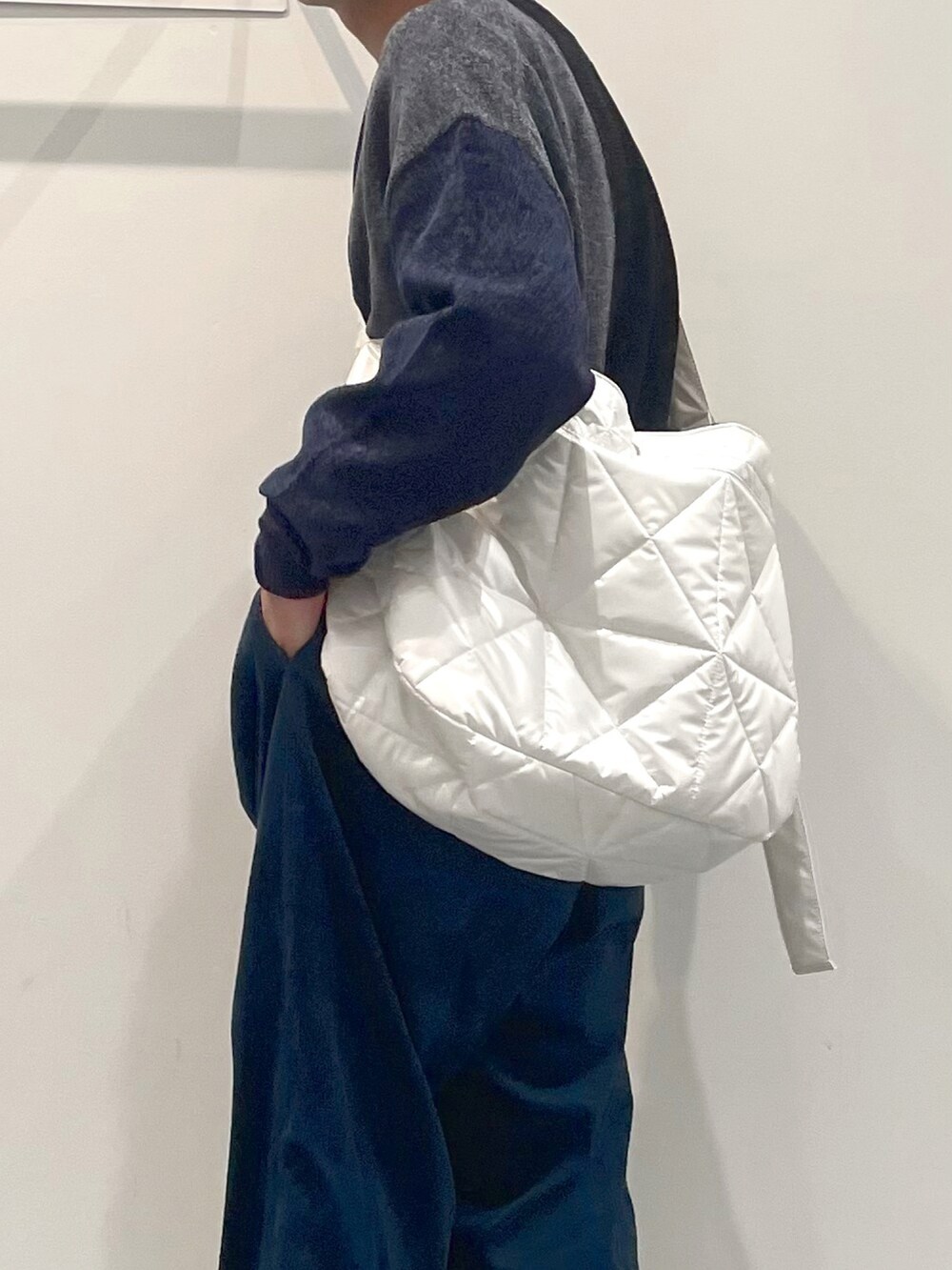 グレー系のニット/セーター、ホワイト系のショルダーバッグ、ブルー系のその他パンツを着用したメンズの秋コーディネートの3枚目の写真