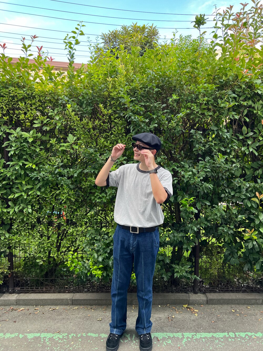 グレー系のTシャツ/カットソー、ブルー系のデニムパンツ、ブラック系のスニーカーを着用したメンズの秋コーディネートの3枚目の写真