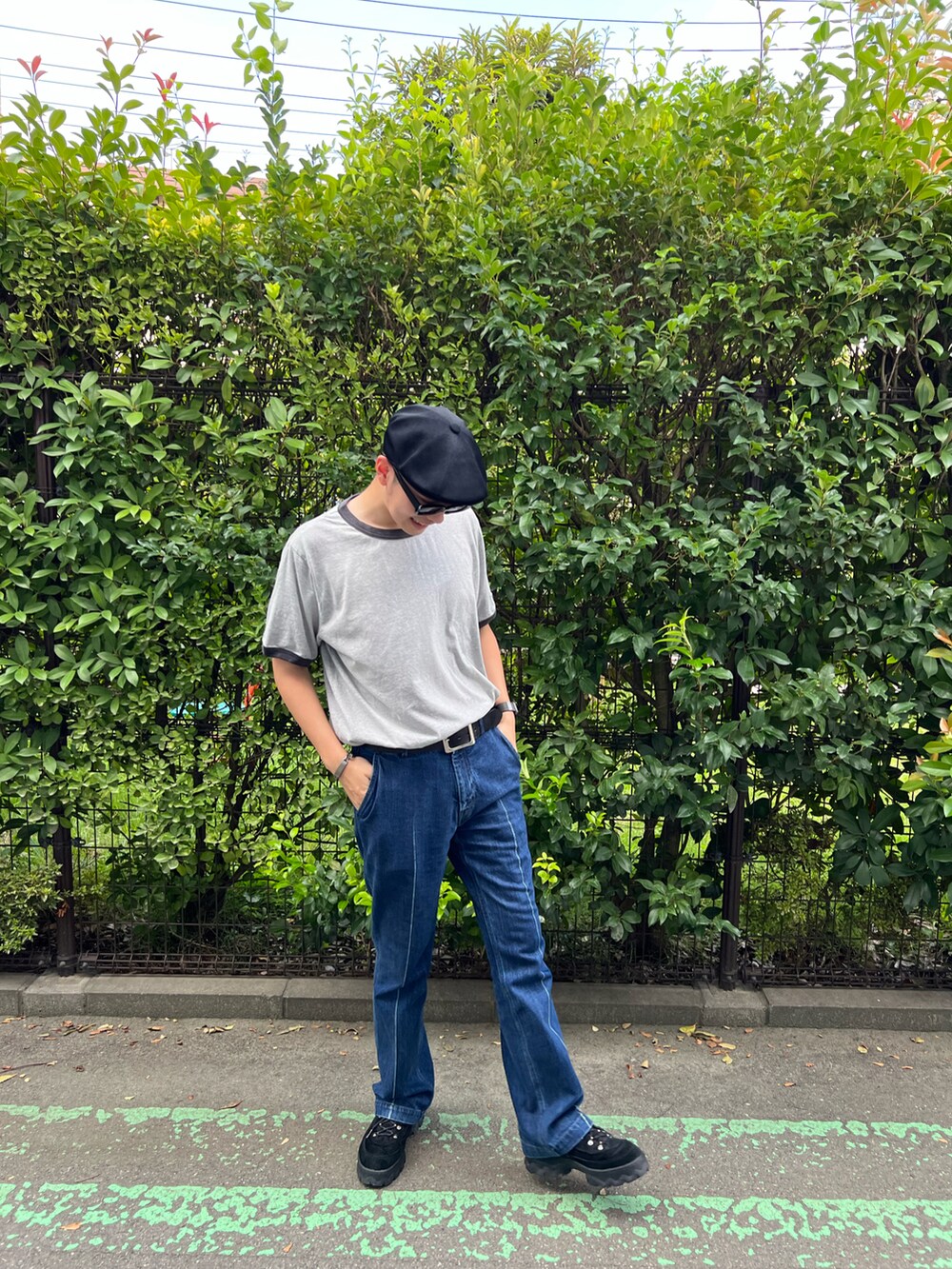 グレー系のTシャツ/カットソー、ブルー系のデニムパンツ、ブラック系のスニーカーを着用したメンズの秋コーディネートの2枚目の写真