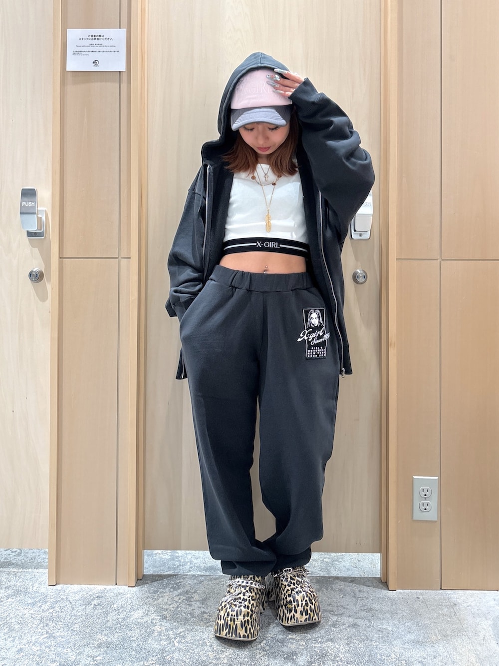 グレー系のパーカー、グレー系のスウェットパンツ、ホワイト系のタンクトップを着用したレディースの夏コーディネートの2枚目の写真