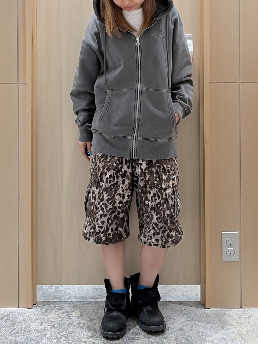 ブラック系のパーカー、ベージュ系のカーゴパンツ、ブラック系のキャップを着用したレディースの冬コーディネートの6枚目の写真