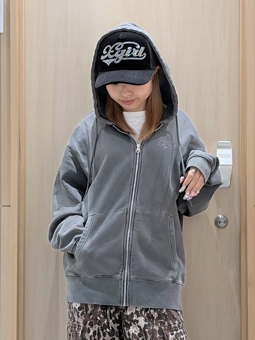 ブラック系のパーカー、ベージュ系のカーゴパンツ、ブラック系のキャップを着用したレディースの冬コーディネートの4枚目の写真