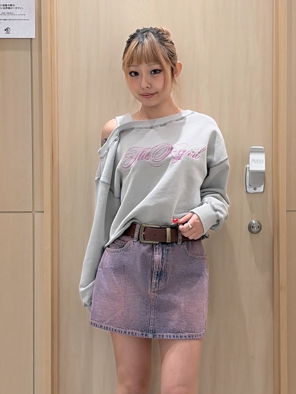 ピンク系のデニムジャケット、ピンク系のデニムスカート、ブラウン系のショルダーバッグを着用したレディースの冬コーディネートの5枚目の写真