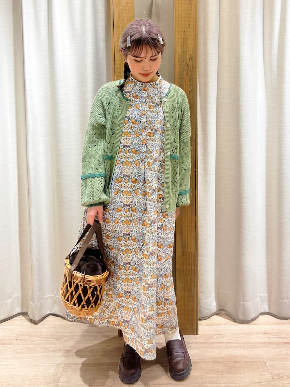 オレンジ系のワンピース、グリーン系のカーディガン/ボレロを着用したレディースの冬コーディネートの4枚目の写真
