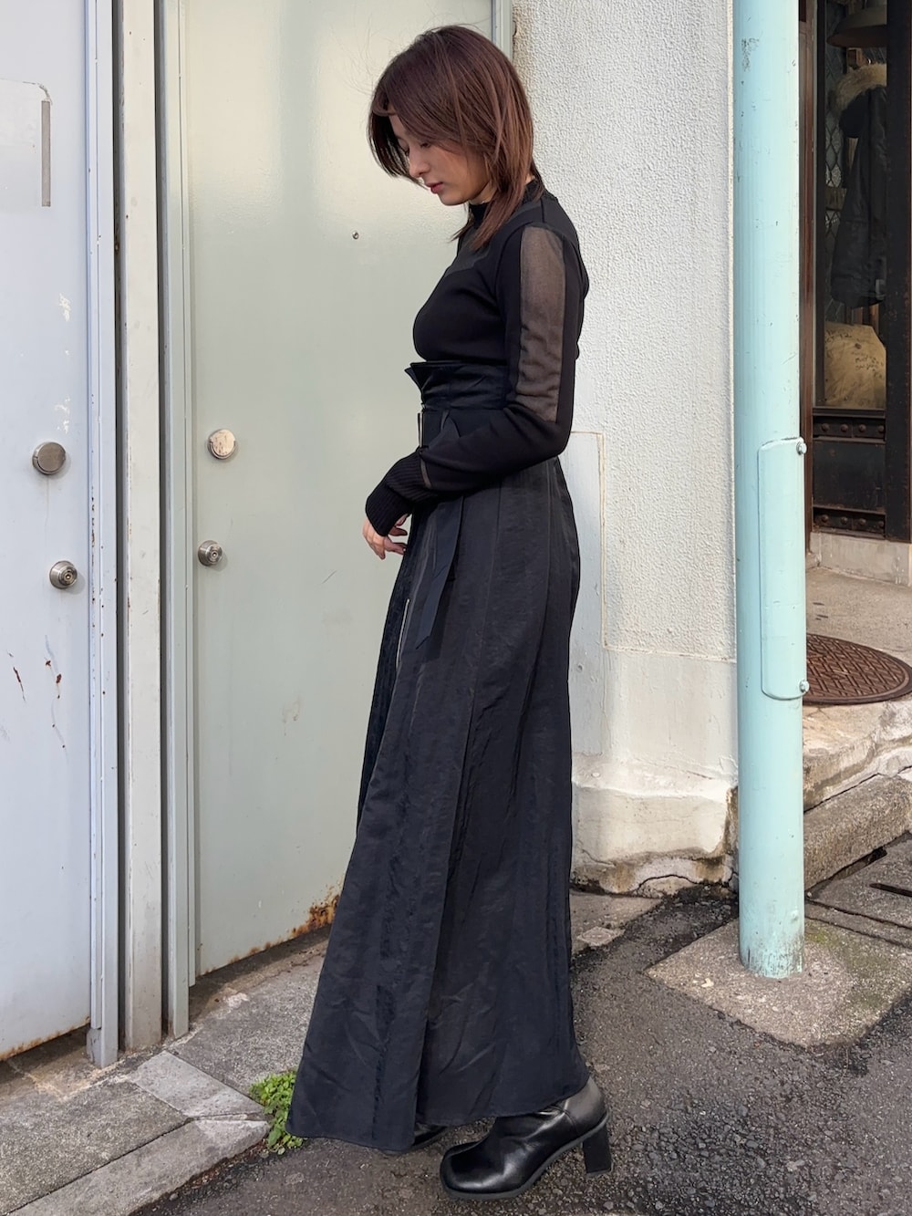 ブラック系のニット/セーター、ブラック系のスカートを着用したレディースの冬コーディネートの3枚目の写真