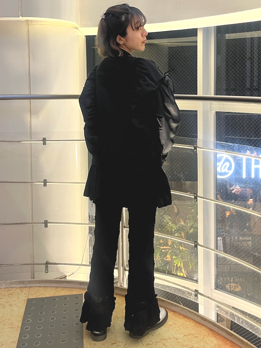 グレー系のニット/セーター、ブラック系のMA-1、ブラック系のスカートを着用したレディースの秋コーディネートの4枚目の写真