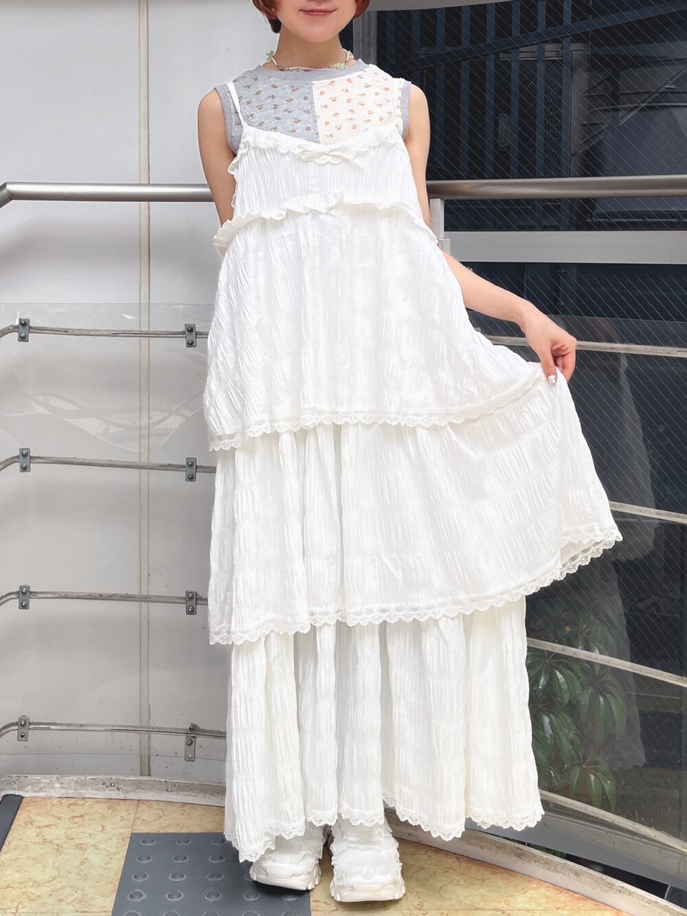 ホワイト系のワンピース、グレー系のタンクトップ、ホワイト系のスニーカーを着用したレディースの春コーディネートの4枚目の写真