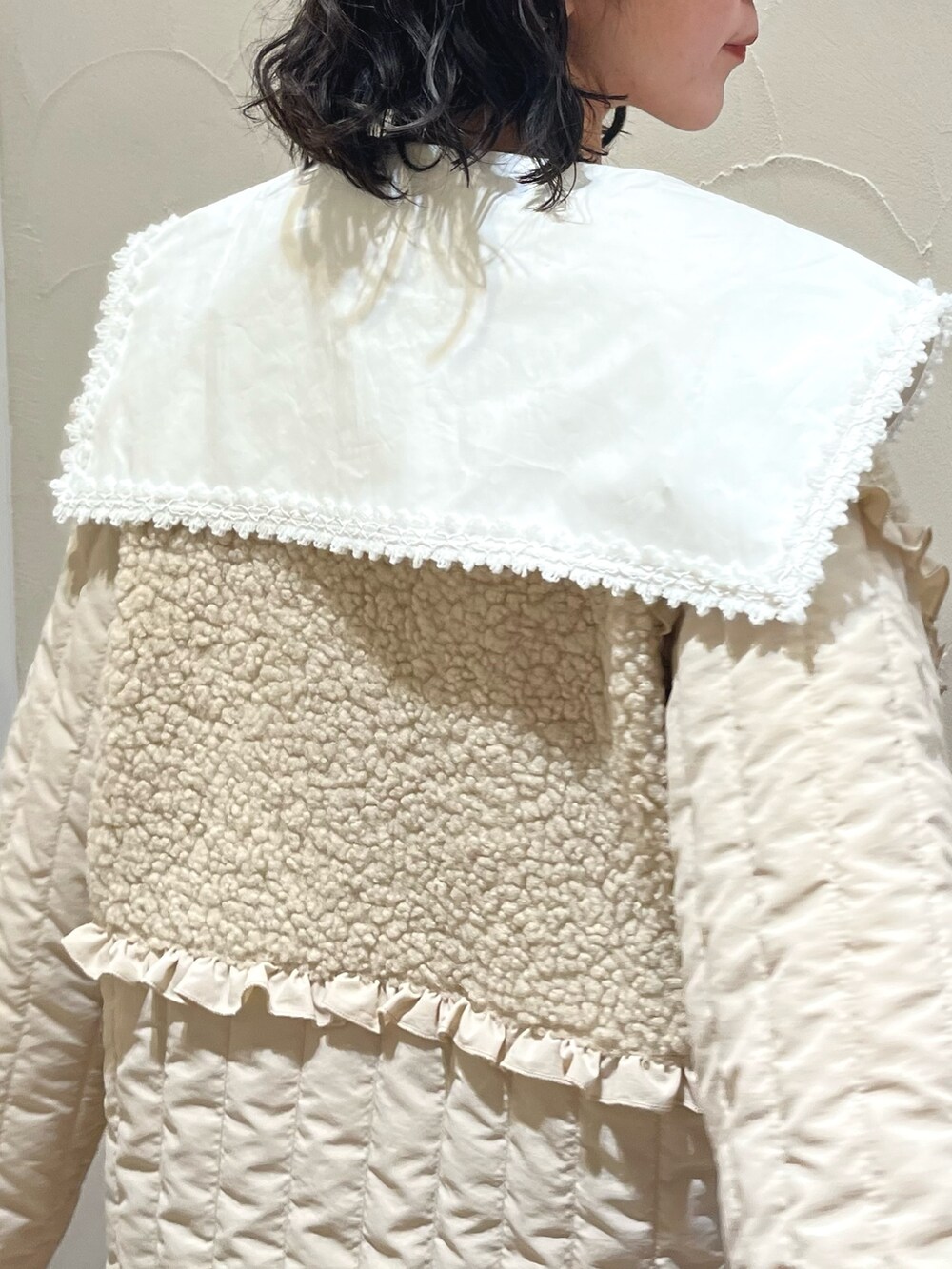 ホワイト系のステンカラーコート、グリーン系のスカート、ブラウン系のブーツを着用したレディースの秋コーディネートの4枚目の写真